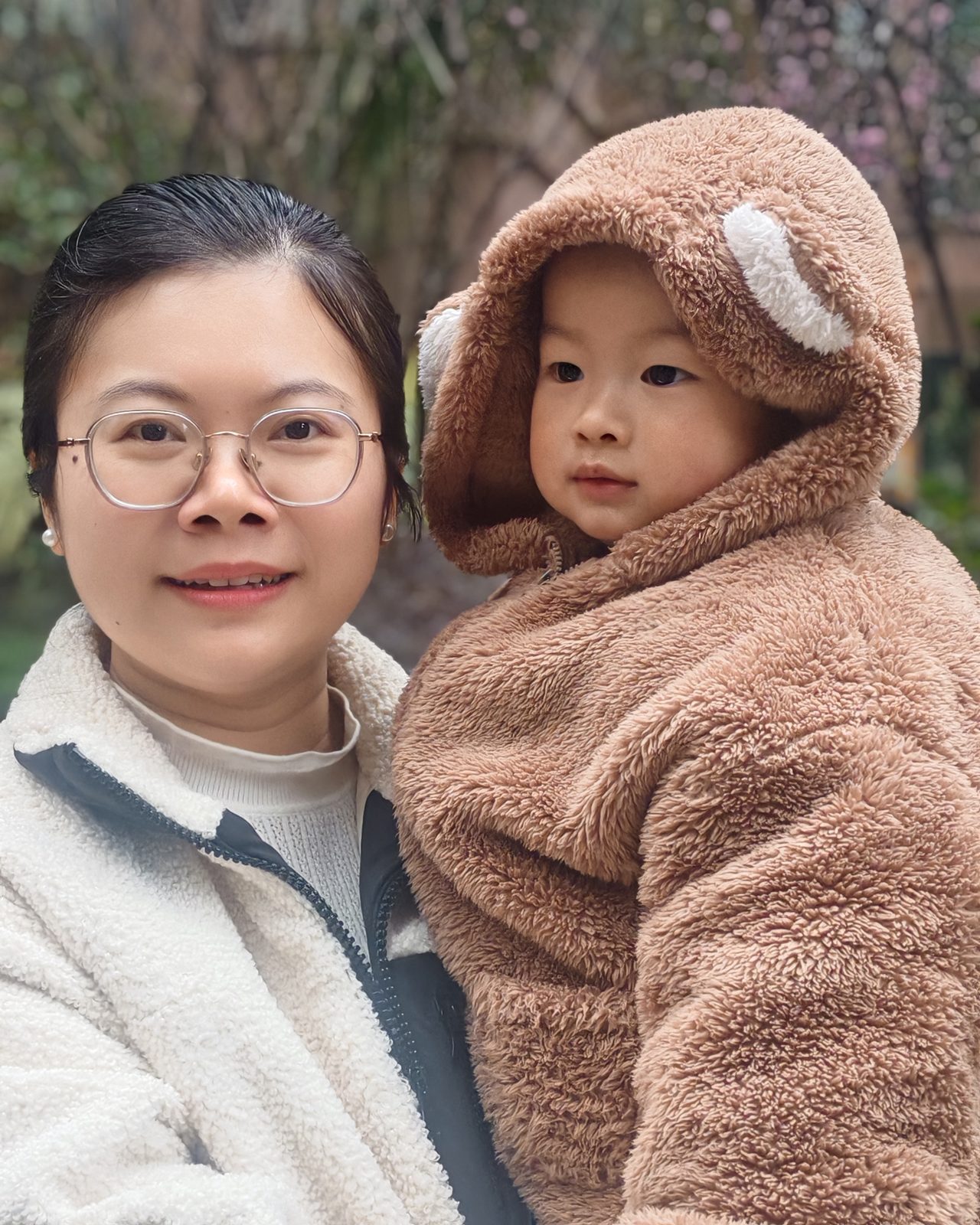妈妈抱着穿毛绒连帽的睿达